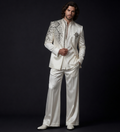 Man wearing an ornate white suit with intricate patterns on a black background