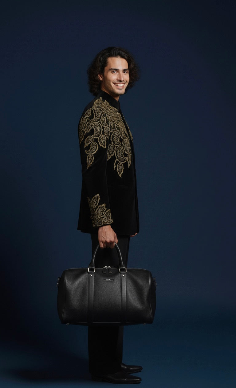 Man wearing a black outfit with gold embroidery