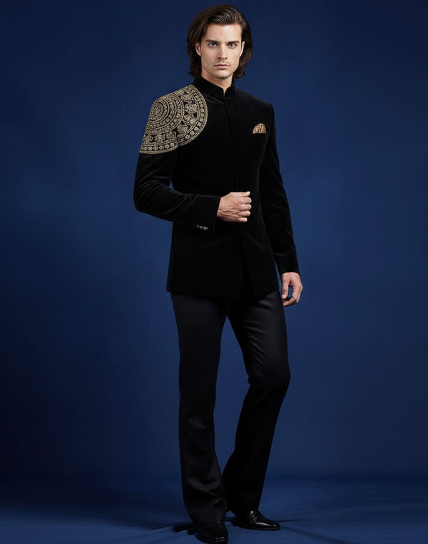 Man wearing a black suit with gold embroidery on a blue background