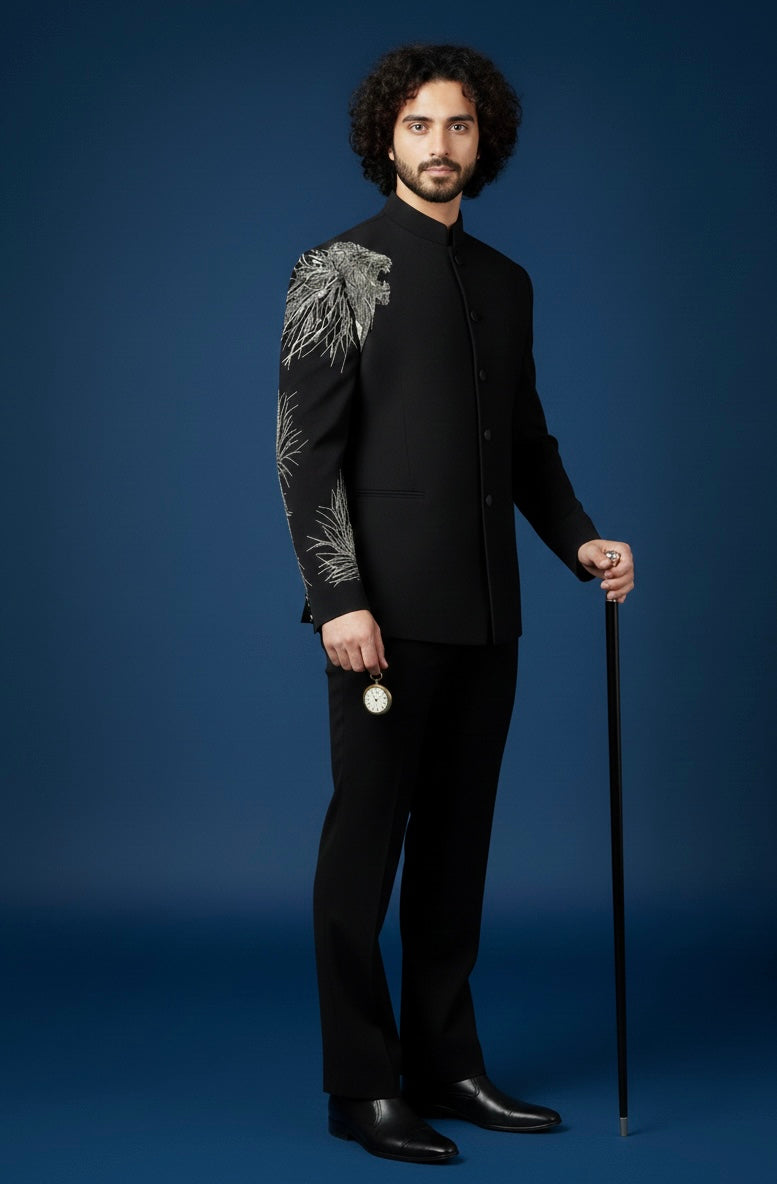 Man in a black suit with intricate patterns on a blue background