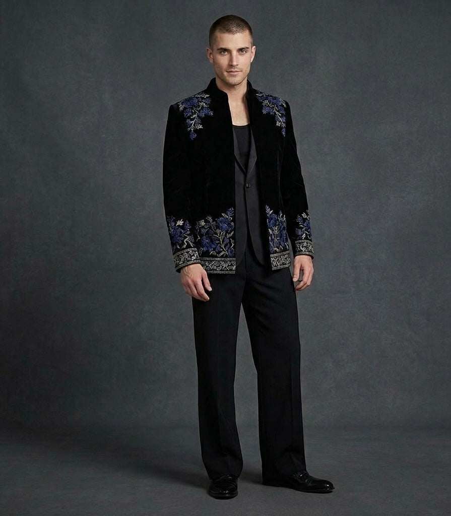 Man wearing a black embroidered jacket on a gray background