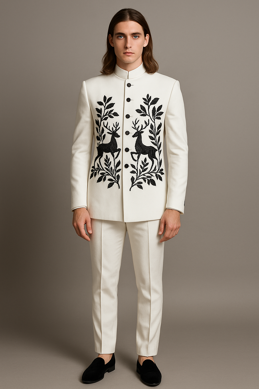 Man wearing a white suit with black deer and floral patterns on a gray background