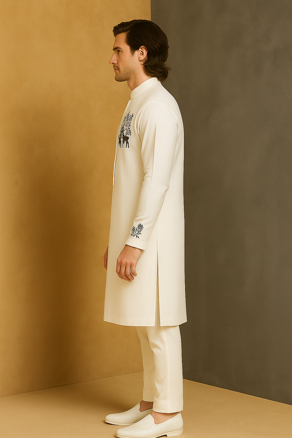 Man wearing a white kurta with embroidery against a beige wall