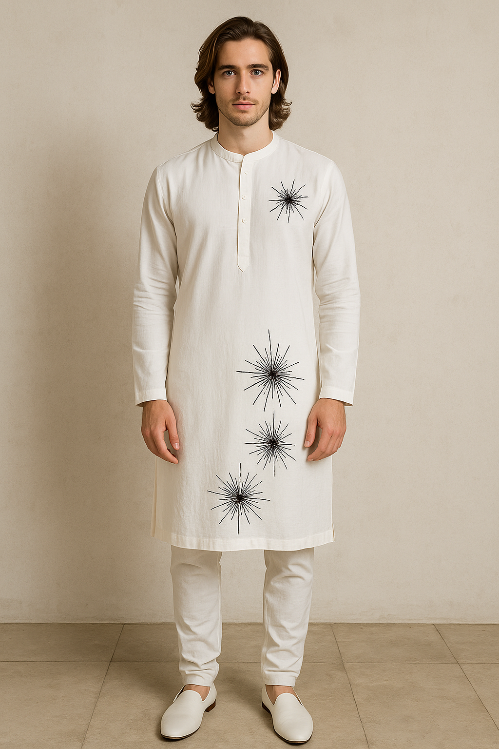 Man wearing a white kurta with black starburst patterns against a beige background