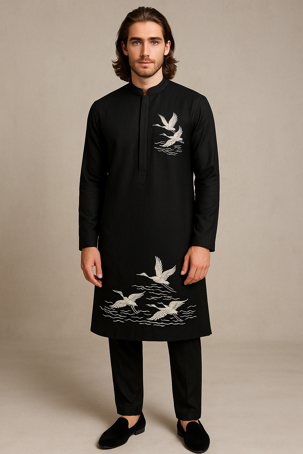 Man wearing a black kurta with white bird embroidery on a beige background