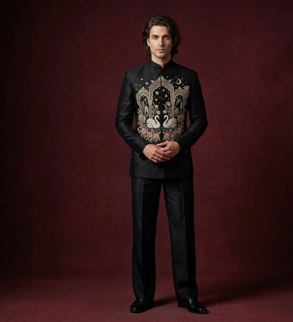 Man wearing a black embroidered suit against a dark red background