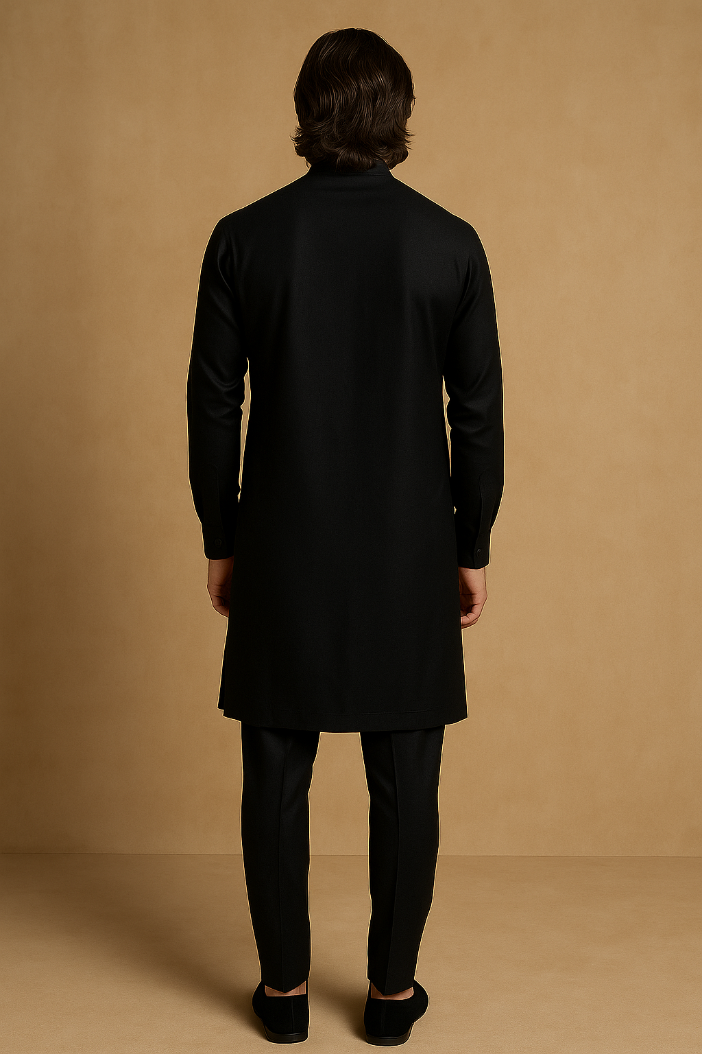 Person wearing a black coat and pants against a beige background