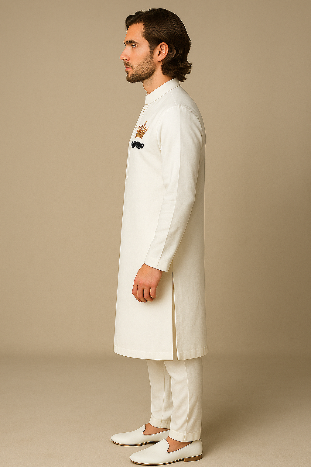 Man wearing a white traditional outfit with embroidery on a beige background