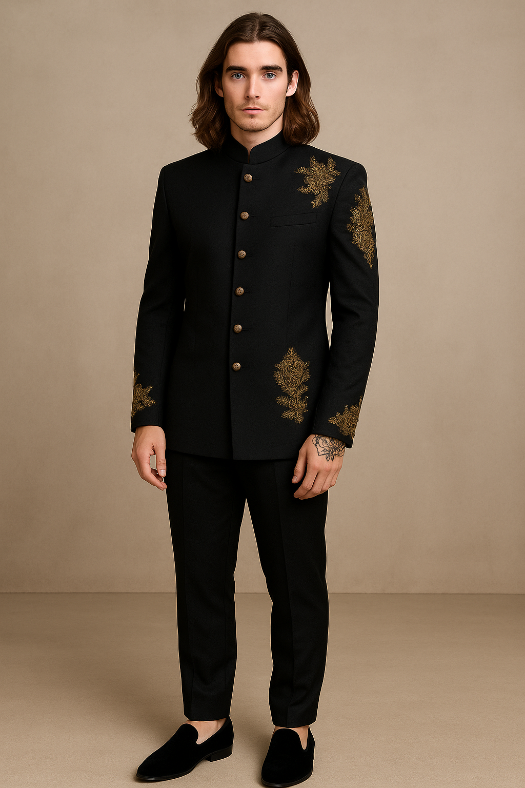 Man wearing a black embroidered jacket and pants against a beige background
